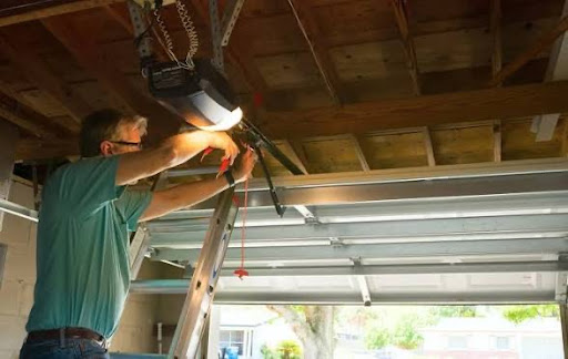 Garage door opener installation Dallas TX - technician servicing ceiling-mounted motor