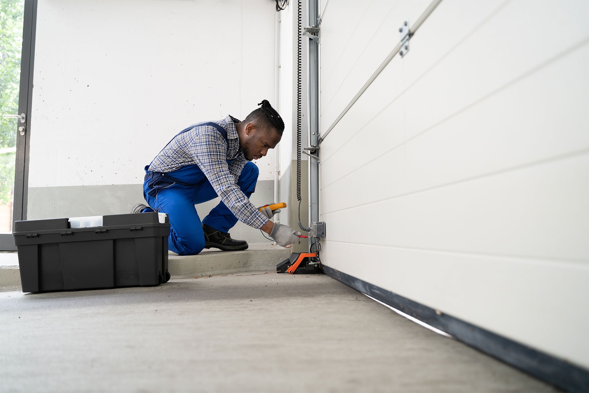 Dallas garage door technician repairing safety sensor and track components