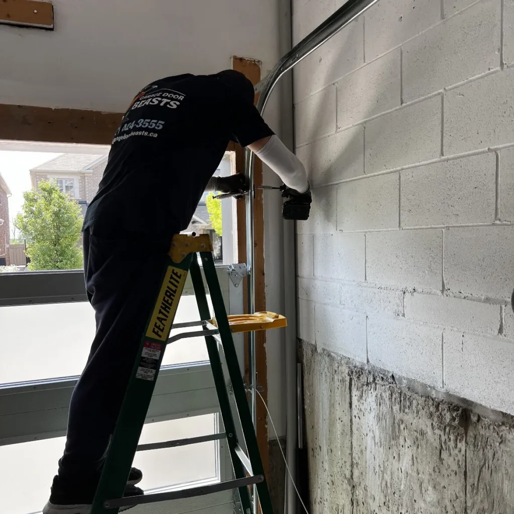 Dallas garage door track repair technician on ladder